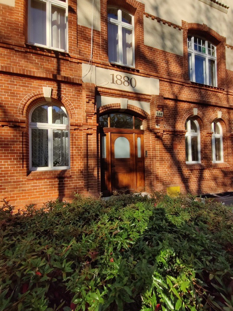 Wejście do kamienicy z tablicą 1880 nad drzwiami i numerem domu 188